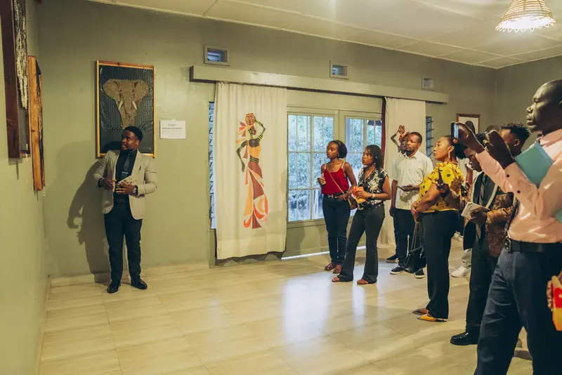 Le public écoute l'artiste au vernissage de l'exposition d'art du fil, juillet 2025