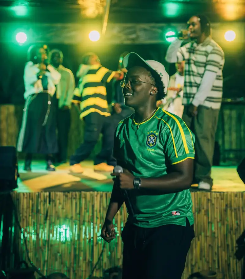 Un artiste en maillot vert chante devant la scène