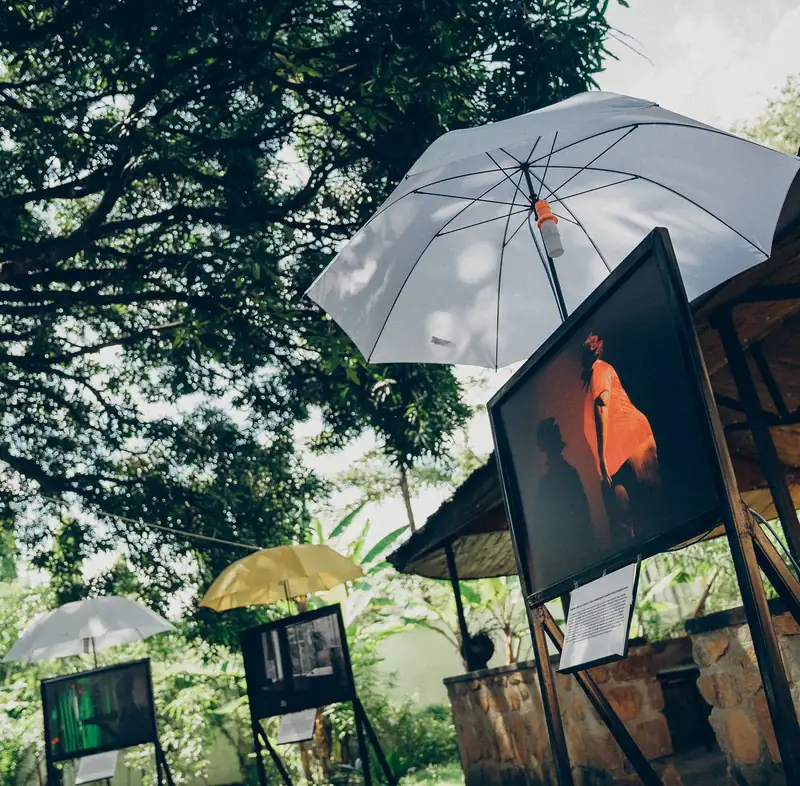 Des photographies exposées sous des parapluies dans le jardin du centre
