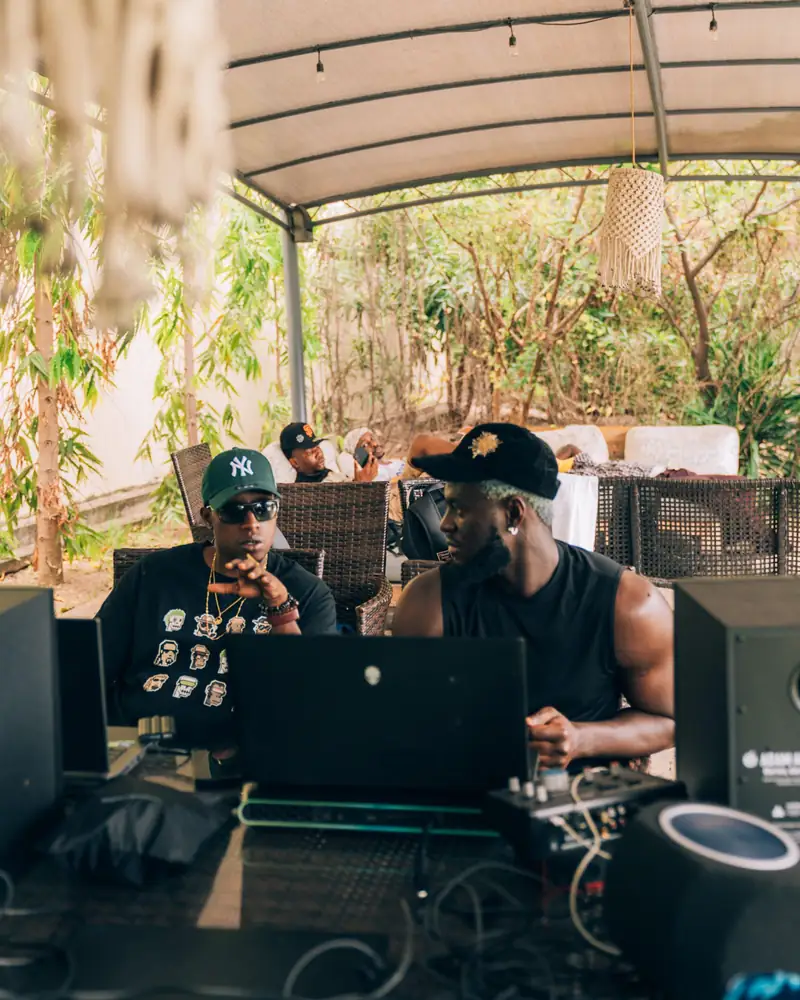 Kel-P échange avec un producteur, devant les enceintes de studio