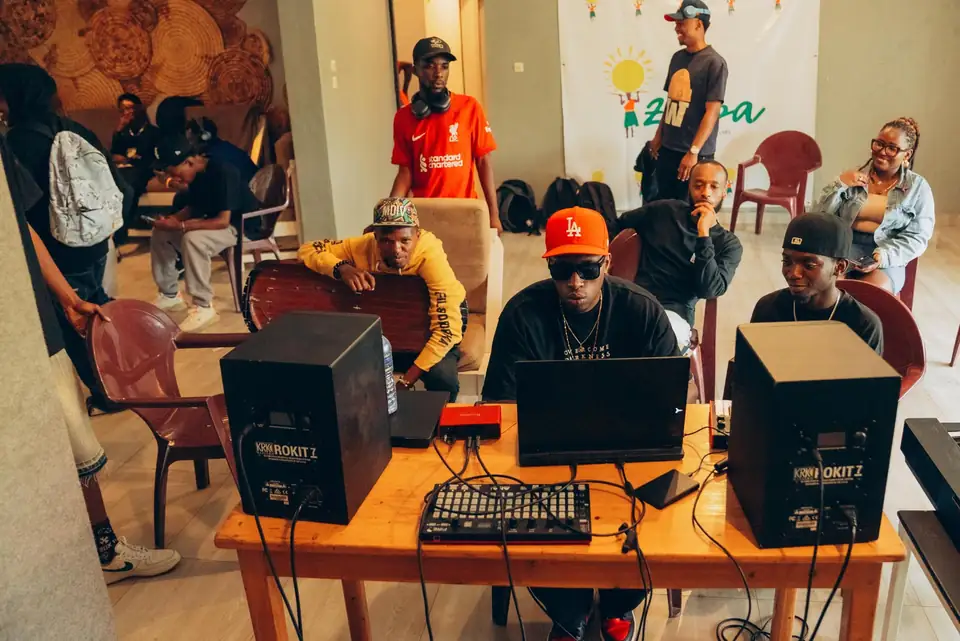 KDaGreat, casquette rouge, aux commandes d'une session, des artistes autour de lui